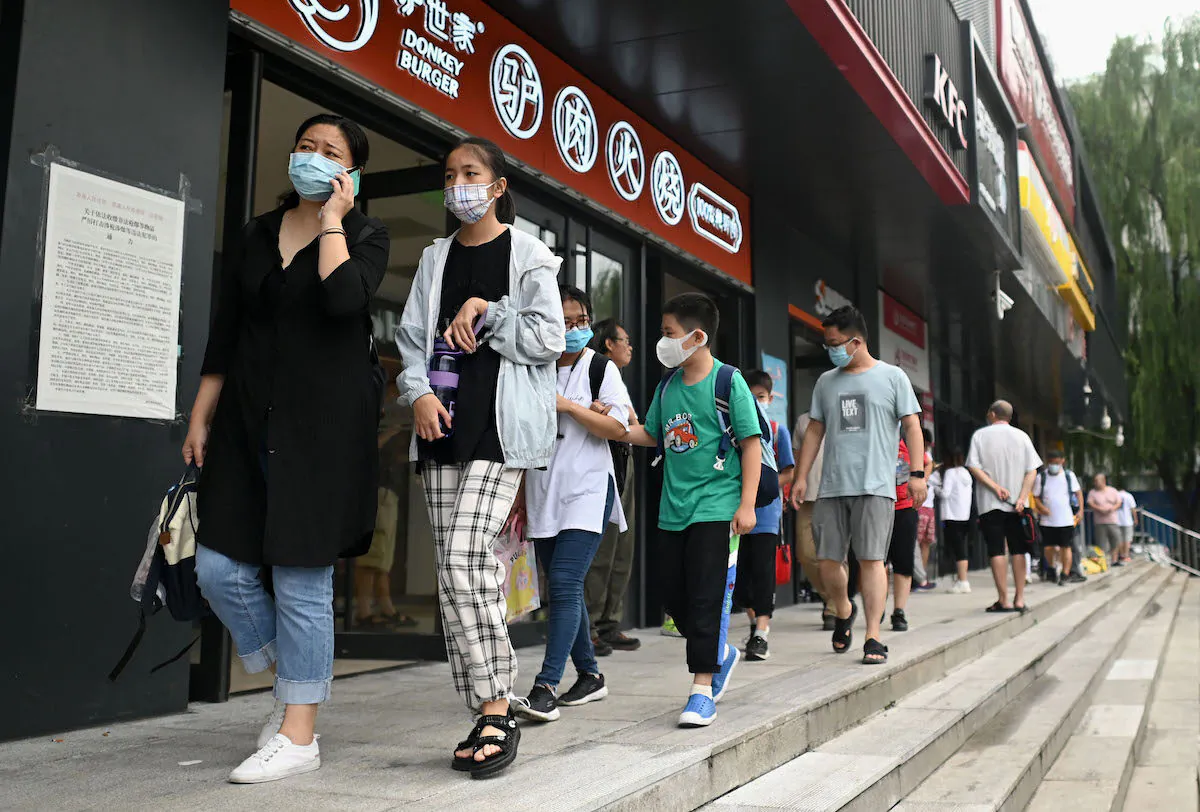 Students walking with their parents after attending a private after-school education in Haidan district of Beijing on July 28, 2021. (Noel Celis/AFP via Getty Images)