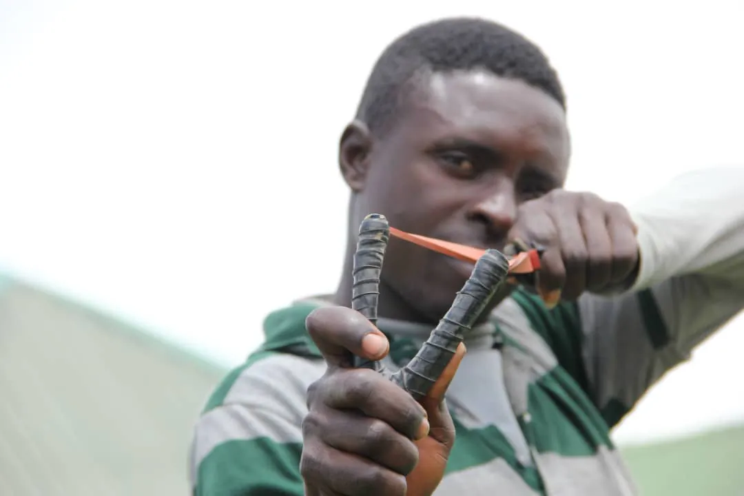 A member of a civilian watch group shows the slingshot he used to oppose terrorists in Rirom County of Plateau State in Nigeria on Aug. 2, 2021. (Masara Kim/The Epoch Times)