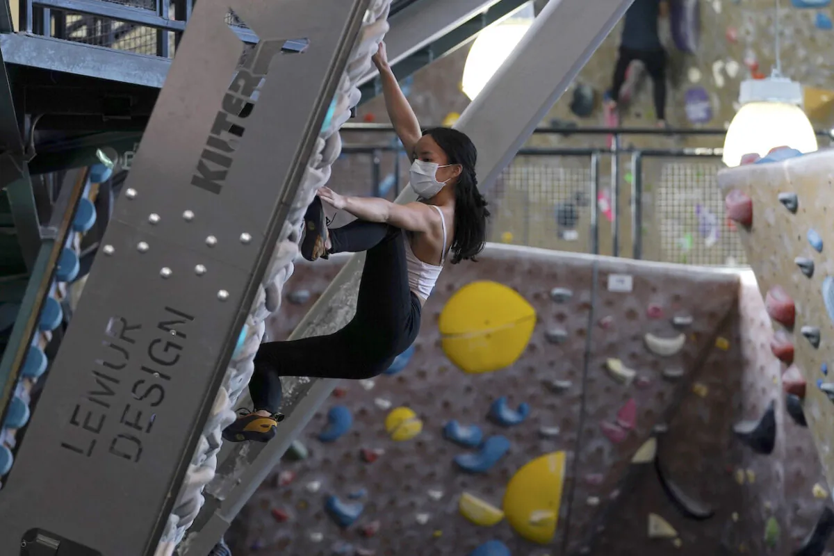 A person wears a protective face mask while working out at Planet Granite climbing gym in San Francisco on March 4, 2021. (AP Photo/Jeff Chiu)