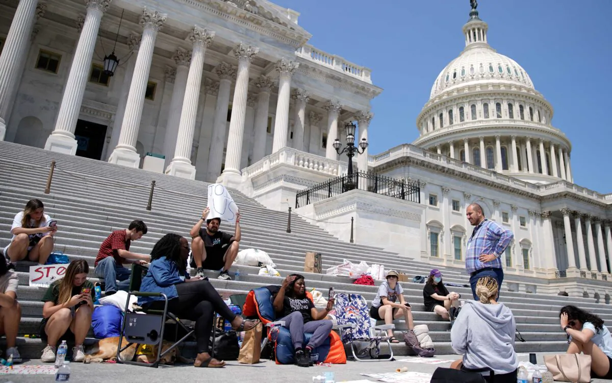 Rep. Cori Bush (D-Mo.) holds up her phone while live streaming from the chair she spent the night in to highlight the upcoming expiration of the pandemic-related federal moratorium on residential evictions on the steps of the Capitol in Washington on July 31, 2021. (Elizabeth Frantz/Reuters)