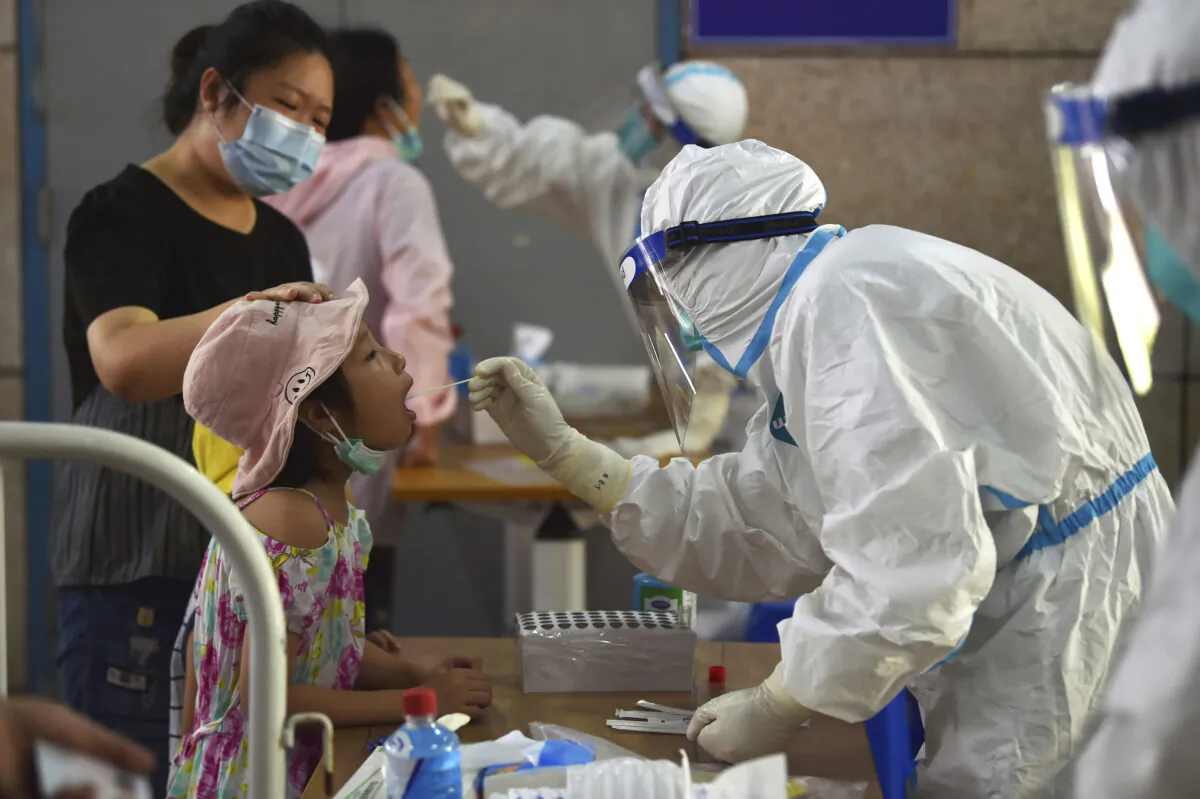 A nurse takes throat swab samples in the new rounds of COVID-19 test in Nanjing in eastern China's Jiangsu Province, on Aug. 2, 2021.   (Chinatopix/Via AP)
