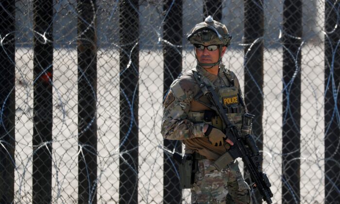 An armed U.S. Customs and Border Patrol agent stands watch at the border fence next to the beach in Tijuana, at the Border State Park in San Diego, Calif., on Nov. 16, 2018. (Mike Blake/File Photo/Reuters)