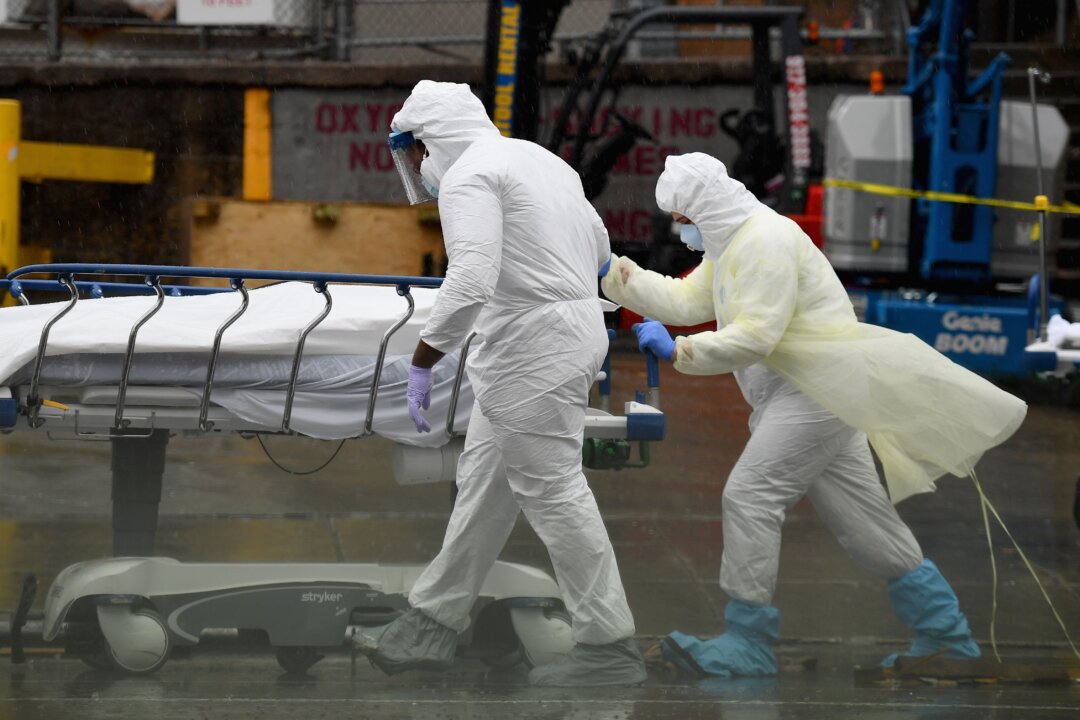 Medical personnel move a deceased patient to a refrigerated truck serving as a make shift morgue, at Brooklyn Hospital Center in New York City, on April 9, 2020. (Angela Weiss/ AFP via Getty Images)