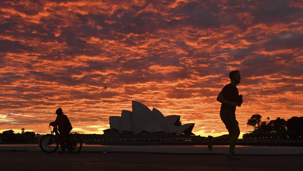 A jogger runs past the Sydney Opera House at dawn in Sydney, July 28, 2021. (Mick Tsikas/AAP Image via AP)