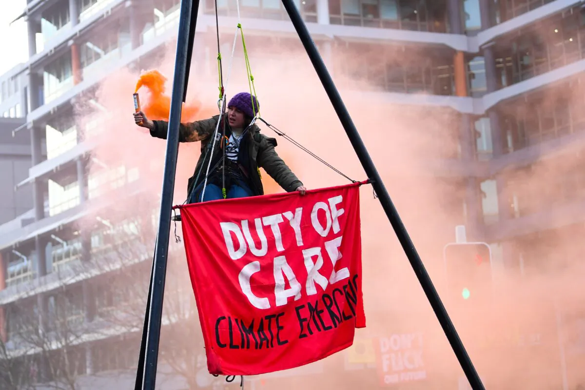 A protester blocking a street during an Extinction Rebellion protest outside the Australian Petroleum Production and Exploration Association (APPEA) building in Canberra, Australia on Aug. 3, 2021. (AAP Image/Lukas Coch)