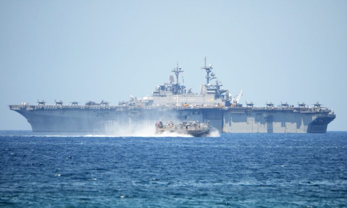 A U.S. Navy hovercraft speeds past the USS Wasp, a multipurpose amphibious assault ship, during the amphibious landing exercises as part of the annual joint U.S.–Philippines military exercise on the shores of San Antonio town, facing the South China sea, Zambales Province in the Philippines, on April 11, 2019. (Ted Aljibe/AFP via Getty Images)