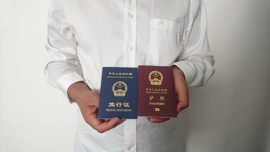 An unidentified Chinese national holds his expired Chinese passport (red) and a one-way travel document (blue) issued in its place by the Chinese mission in Saudi Arabia, in Medina on Oct. 2, 2019. (AFP via Getty Images)