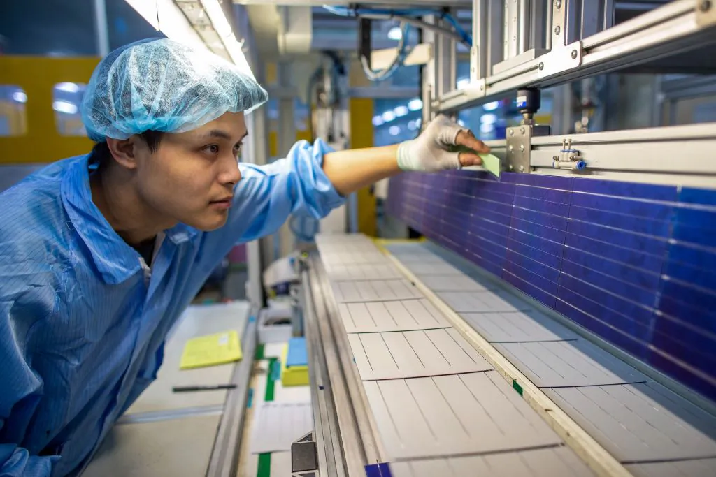This photo taken on April 11, 2021 shows a worker producing photovoltaic solar parts at a factory in Haian, in China's eastern Jiangsu province. - China OUT (Photo by STR / AFP) / China OUT (Photo by STR/AFP via Getty Images)