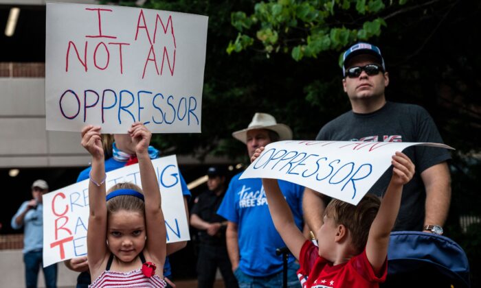 Children hold up signs during a rally against critical race theory being taught in schools at the Loudoun County Government center in Leesburg, Va., on June 12, 2021. (Andrew Caballero-Reynolds/AFP via Getty Images)