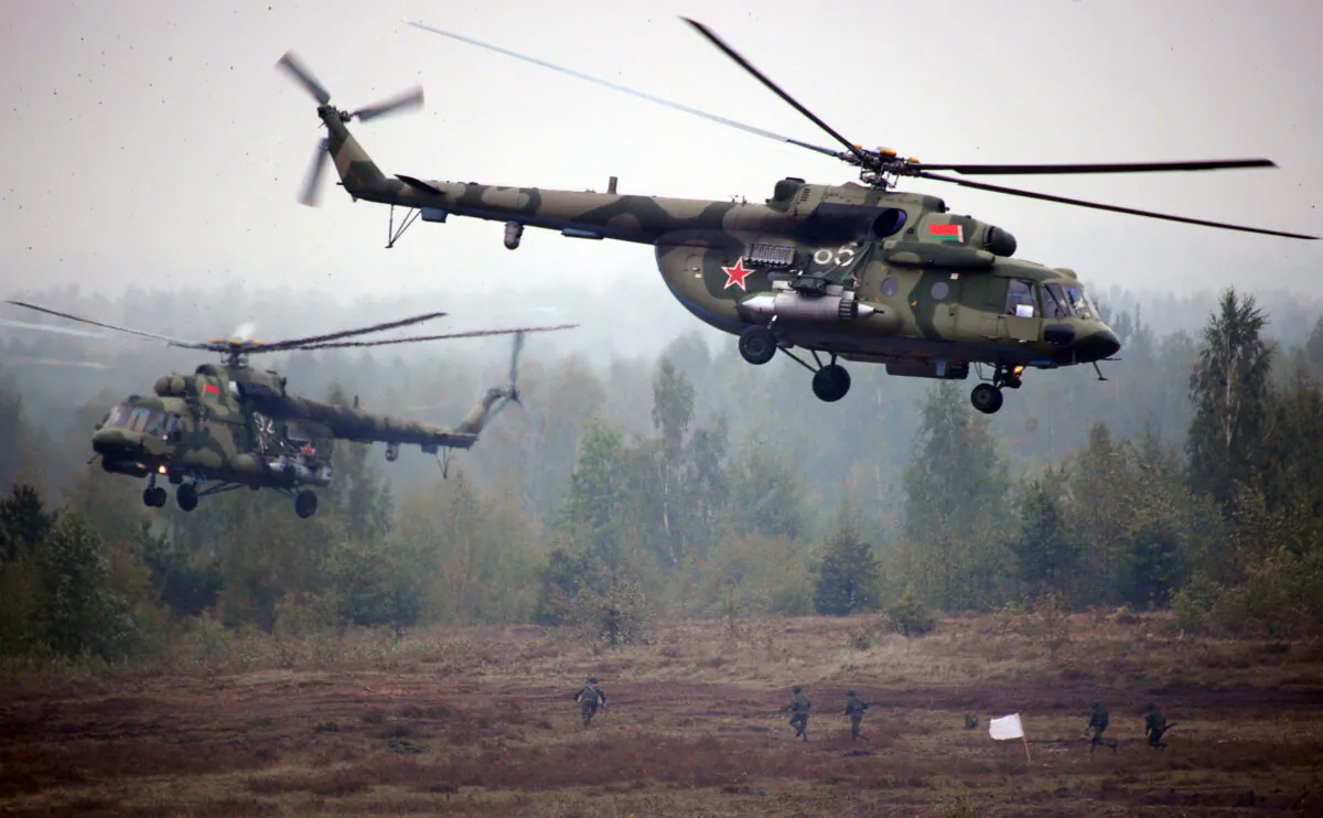 Helicopters fly above servicemen running to positions during the joint Russian–Belarusian military exercises Zapad-2017 (West-2017) at a training ground near the town of Borisov on Sept. 20, 2017. (Sergei Gapon/AFP via Getty Images)