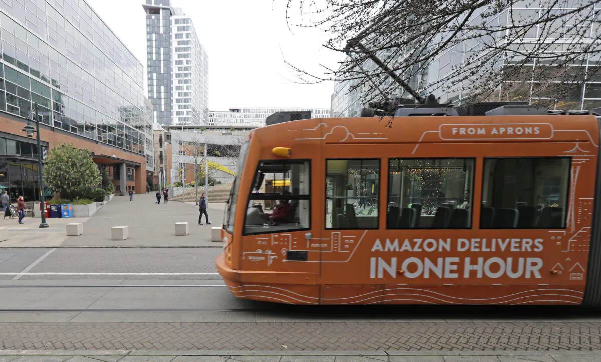 A South Lake Union streetcar with an advertisement for Amazon.com's same-day delivery service passes by an Amazon office building in Seattle's South Lake Union neighborhood, Wash., on Nov. 13, 2018. (Ted S. Warren/AP Photo)