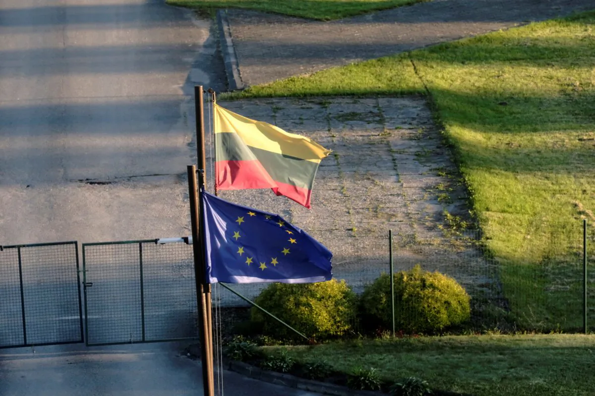 Lithuanian and European Union flags flutter at the Lithuanian border guards unit headquarters near Adutiskis, Lithuania, on June 15, 2021. (Ints Kalnins/Reuters)