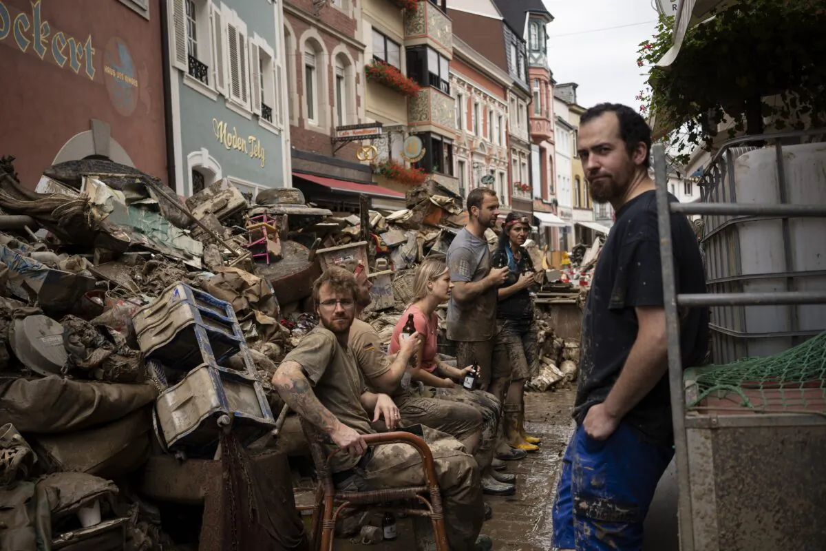 People take a break from cleaning the debris from the flood disaster in Bad Neuenahr-Ahrweiler, Germany, on July 19, 2021. (Bram Janssen/AP Photo)
