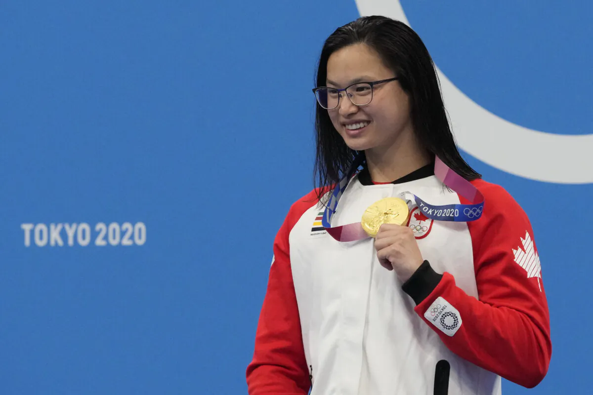 Margaret Mac Neil of Canada poses with her gold medal after winning the women's 100-meter butterfly at the Summer Olympics in Tokyo, Japan, on July 26, 2021. (AP Photo/Petr David Josek)