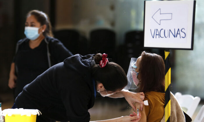 A health worker vaccinates a citizen over 60 years old with the Sinovac vaccine on March 19, 2021, in Santiago, Chile. (Marcelo Hernandez/Getty Images)