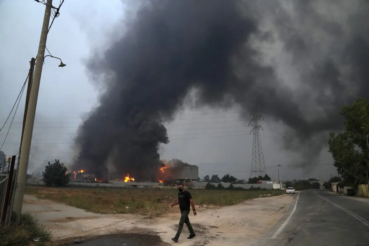 A car recycling plant is on fire during a wildfire in Afidnes village, about 19 miles (31 kilometres) north of Athens, Greece on Aug. 6, 2021. (Thanassis Stavrakis/AP Photo)
