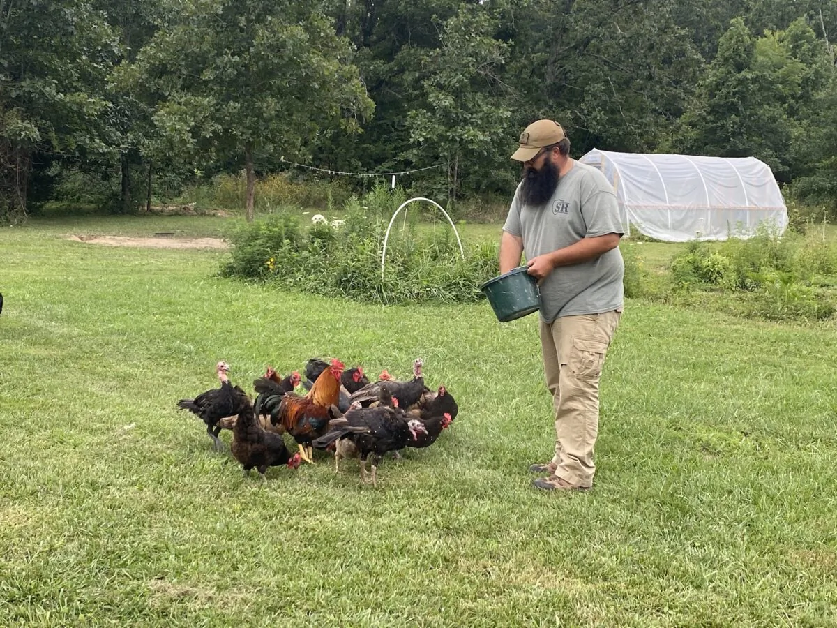Travis Maddox, a prepper and producer of "The Prepared Homestead" on YouTube, feeds his turkeys and chickens. (Courtesy Travis Maddox)