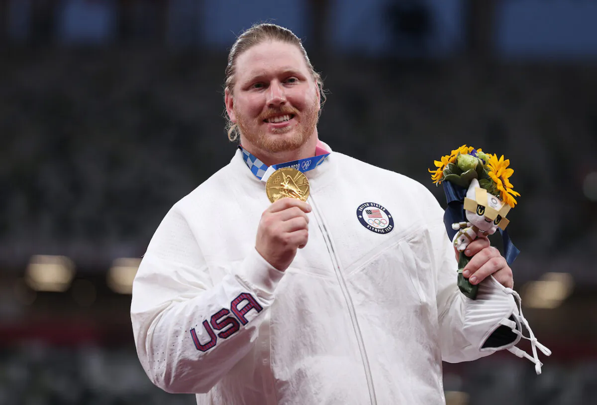 Gold medalist Ryan Crouser of Team United States holds up his medal on the podium during the medal ceremony for the Men’s Shot Put on day thirteen of the Tokyo 2020 Olympic Games at Olympic Stadium in Tokyo, Japan, on Aug. 05, 2021. (Michael Steele/Getty Images)