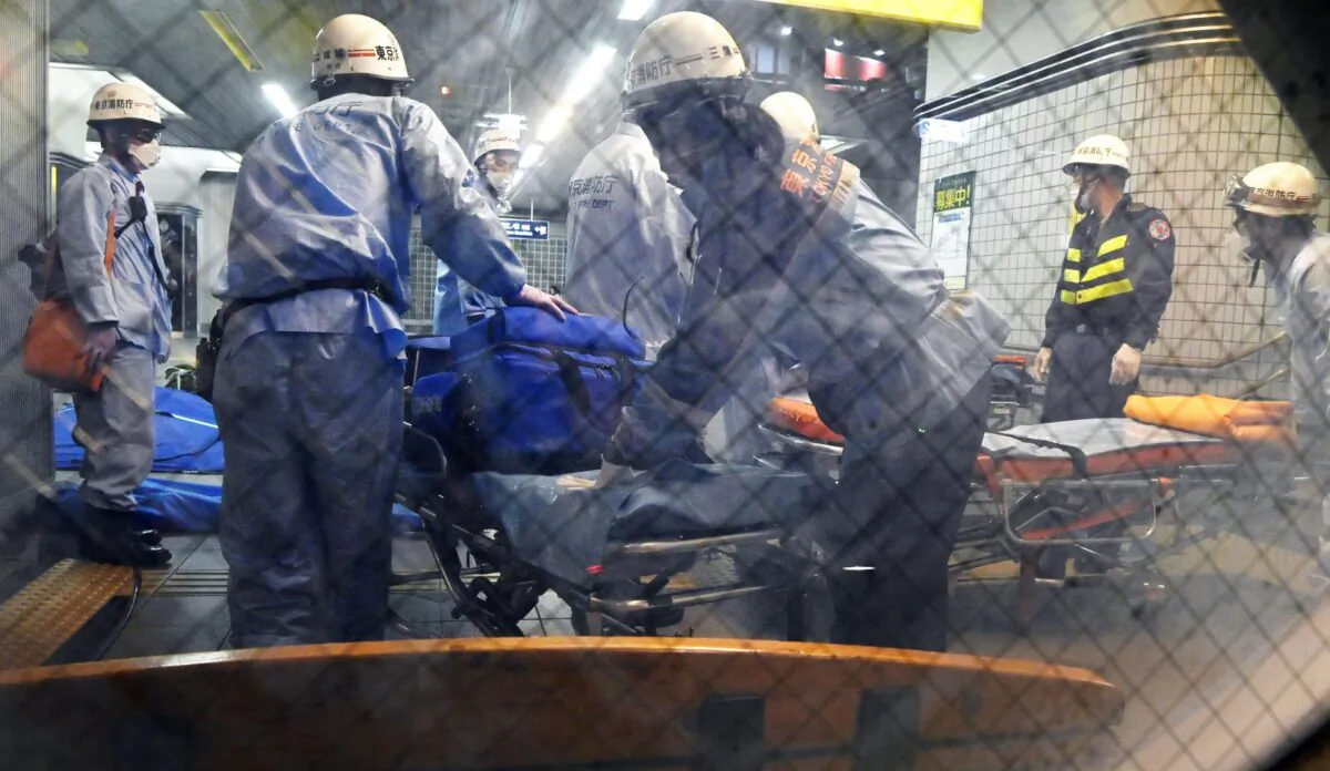 Rescuers papare stretchers at Soshigaya Okura Station after stabbing on a commuter train, in Tokyo, Japan, on Aug. 6, 2021. (Kyodo News via AP)