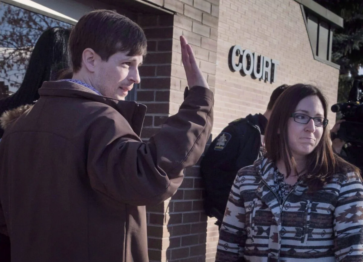 Eddie Maurice waves to supporters outside the court with his wife, Jessica, in Okotoks, Alta., on March 9, 2018. All charges were dropped against Maurice, who wounded a trespasser on his rural property with a ricochet from a warning shot. (The Canadian Press/Jeff McIntosh)