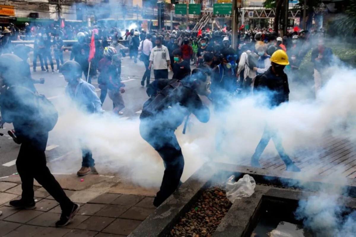 Demonstrators react to tear gas during a clash with police at a protest against what they call the government's failure in handling the coronavirus disease outbreak, in Bangkok, Thailand, on Aug. 7, 2021. (Soe Zeya Tun/Reuters)