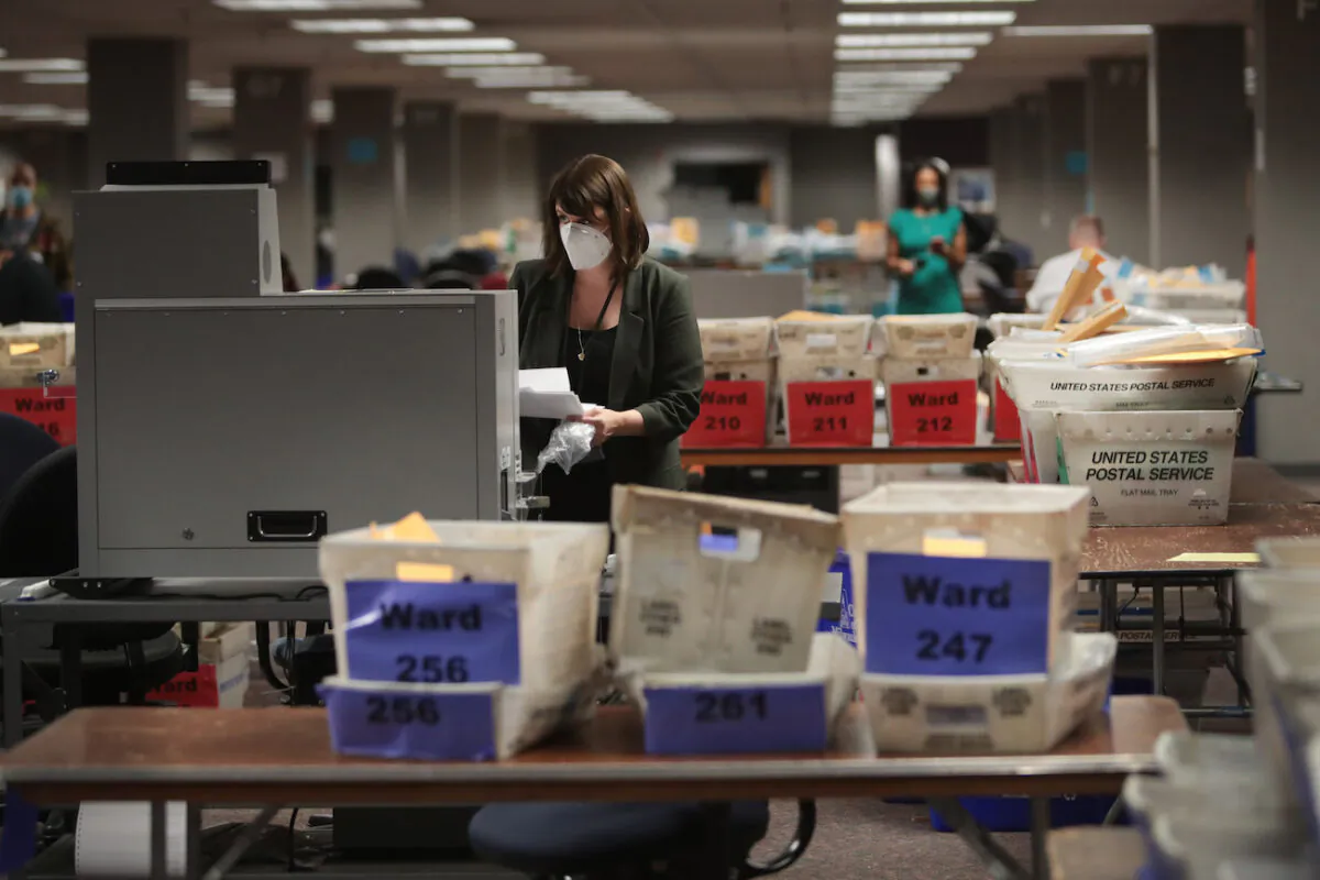 An official is seen collecting the count from absentee ballots from a voting machine in Milwaukee on Nov. 4, 2020. (Scott Olson/Getty Images)