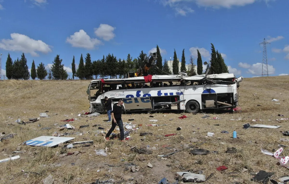 Officials investigate at the site of a bus crash, in Balikesir, western Turkey, on Aug. 8, 2021. (IHA via AP)