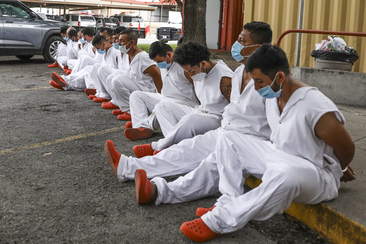 Illegal immigrants wait to be magistrated on trespassing charges in Kinney County outside the Sheriff's Office in Brackettville, Texas, on Aug. 6, 2021. (Charlotte Cuthbertson/The Epoch Times)
