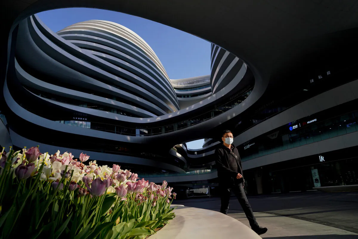 A Chinese man wears a protective mask as he looks at Galaxy SOHO in Beijing on April 20, 2020. (Lintao Zhang/Getty Images)