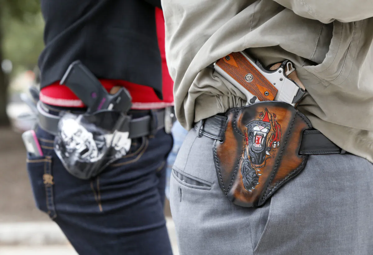 Two 2nd Amendment activists carry guns in custom-made holsters during an open carry rally at the Texas State Capitol in Austin, Texas on Jan. 1, 2016. (Erich Schlegel/Getty Images)