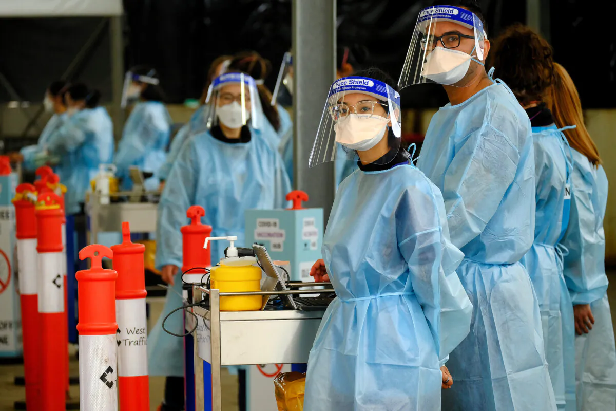 Victorian Health Workers prepare to start the new drive through COVID-19 vaccination centre in Melbourne's Melton on Aug. 8, 2021. (AAP Image/Luis Ascui)