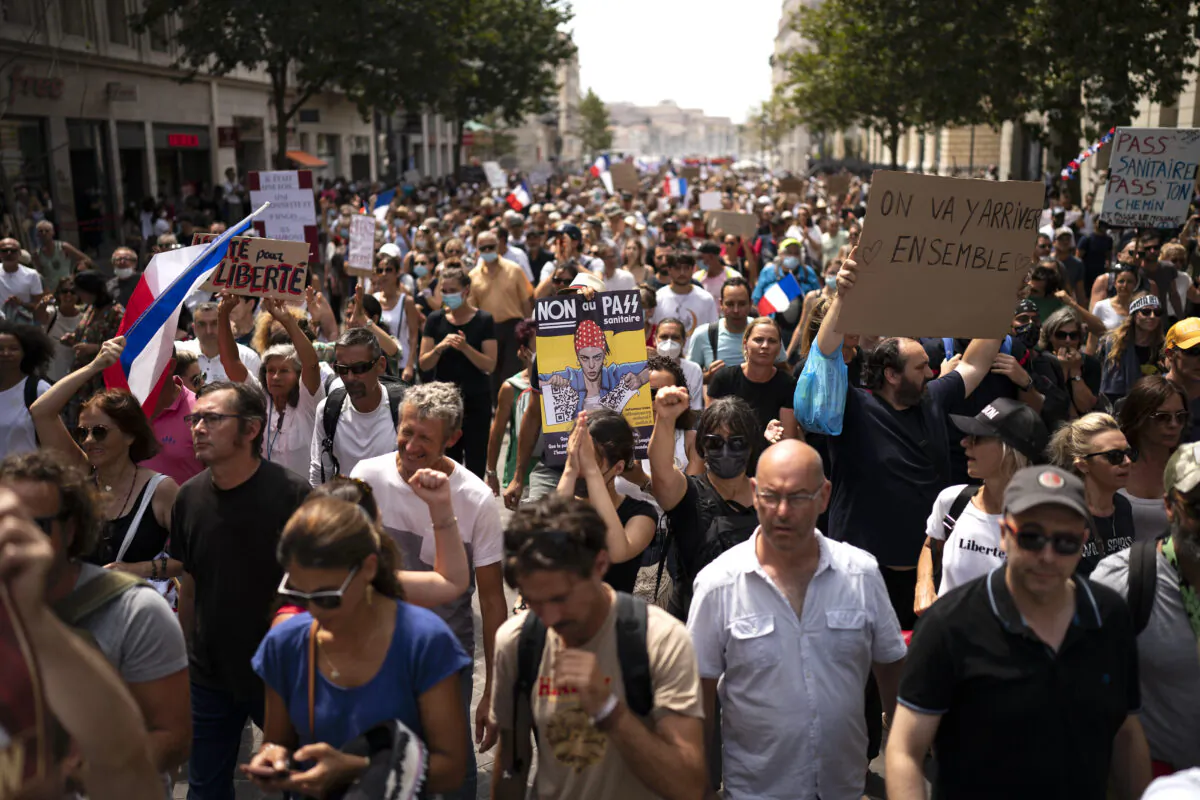A protester holds a sign that reads "No to the health pass" during a demonstration in Marseille, southern France, on Aug. 7, 2021. (Daniel Cole/AP Photo)