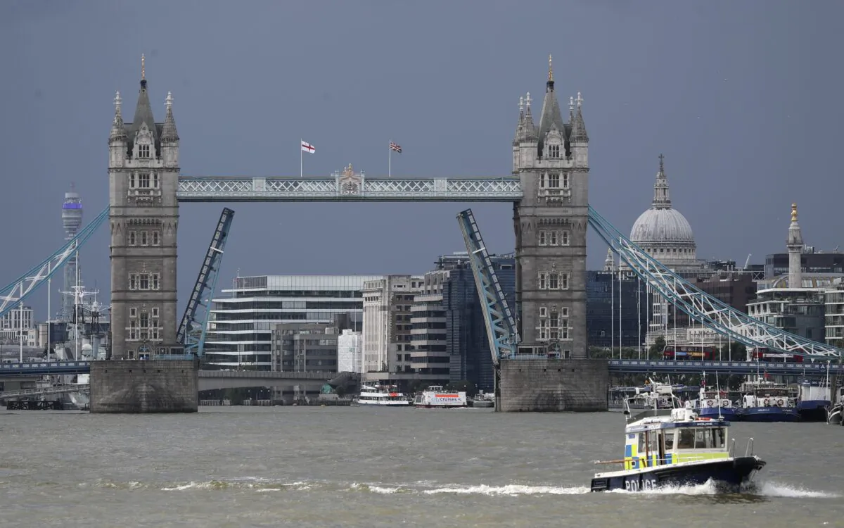 A police boat sails down the River Thames in London on Aug. 9, 2021, in front of Tower Bridge that is stuck in the fully open position due to a technical fault. (Tony Hicks/AP Photo)