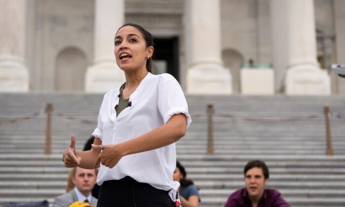 Rep. Alexandria Ocasio-Cortez (D-NY) talks with a reporter as she protests the expiration of the federal eviction moratorium on the House steps of the U.S. Capitol on Aug. 3, 2021. (Drew Angerer/Getty Images)
