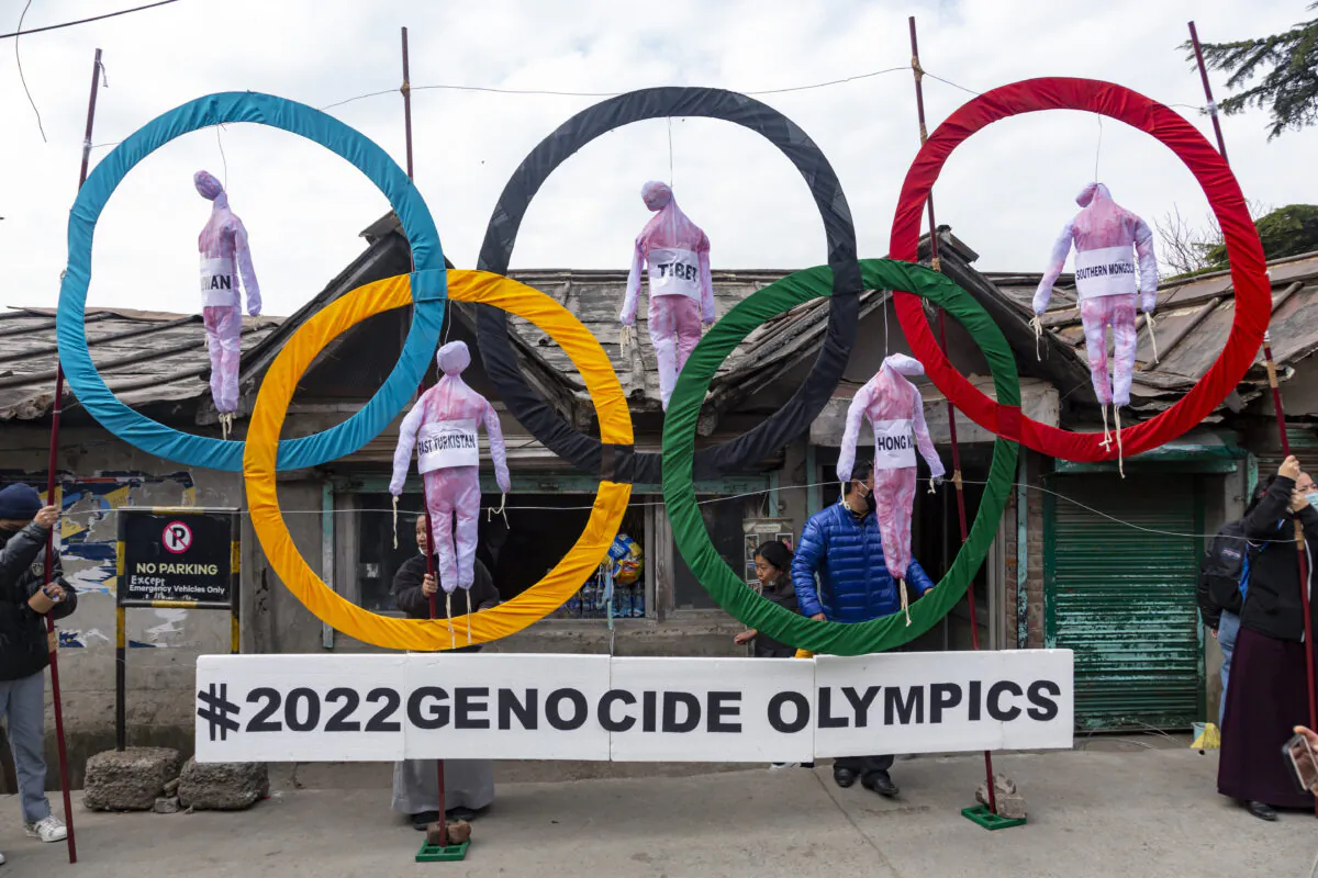 Exiled Tibetans use the Olympic rings as a prop as they protest against the 2022 Beijing Winter Olympics, in Dharmsala, India, on Feb. 3, 2021. (AP Photo/Ashwini Bhatia, File)