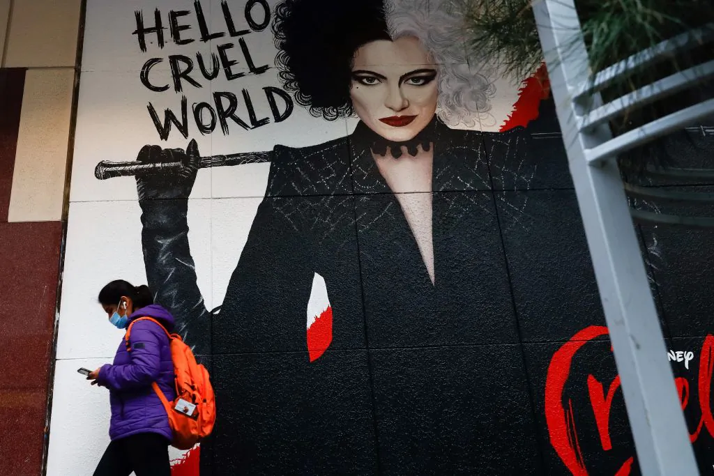 A masked pedestrian walks past a poster for the film Cruella in downtown Melbourne, Australia, on Aug. 6, 2021, amid a sixth lockdown for the city. (Con Chronis/AFP via Getty Images)