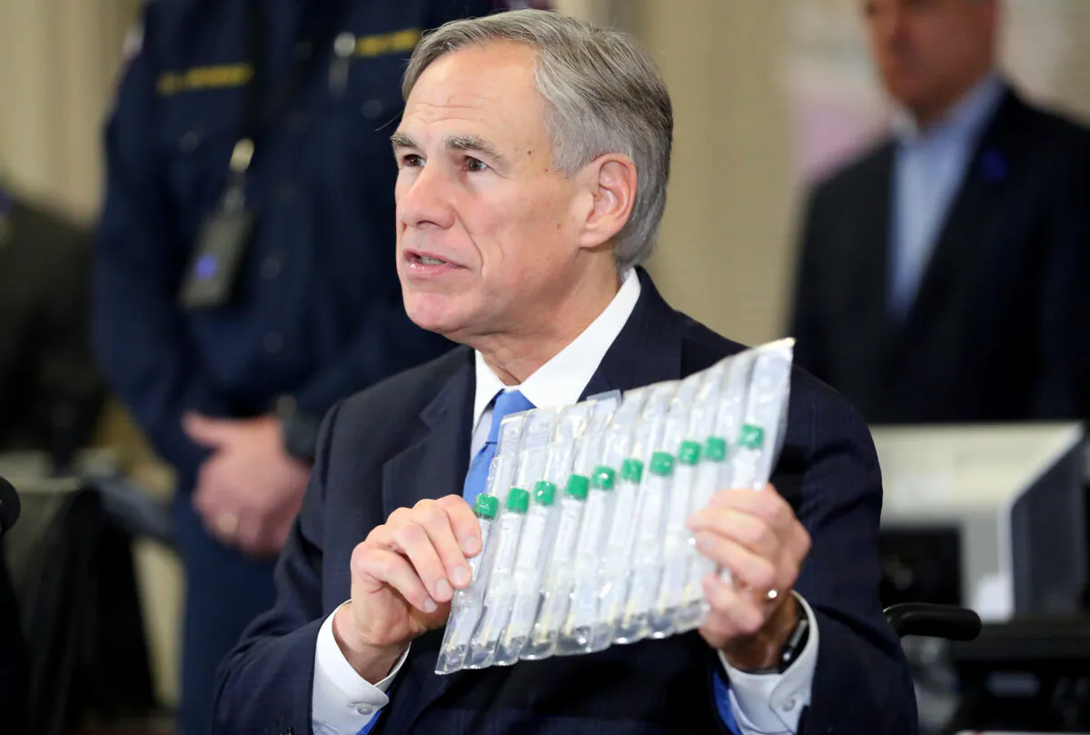 Texas Governor Greg Abbott displays COVID-19 test collection vials as he addresses the media during a press conference held at Arlington Emergency Management in Arlington, Texas, on March 18, 2020. (Tom Pennington/Getty Images)
