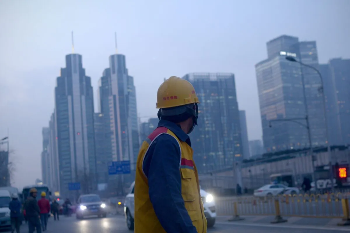A Chinese worker walks along a street after work in Beijing on Dec. 28, 2015. Construction workers, machine operators in factories, office cleaners—the sweat of their brows has contributed to China's economic growth. But while they are free to move in search of employment, they and their children have long been denied equal access to public services such as schools, hospitals and housing under a decades-old household registration system known as "hukou." (Wang Zhao/AFP via Getty Images)