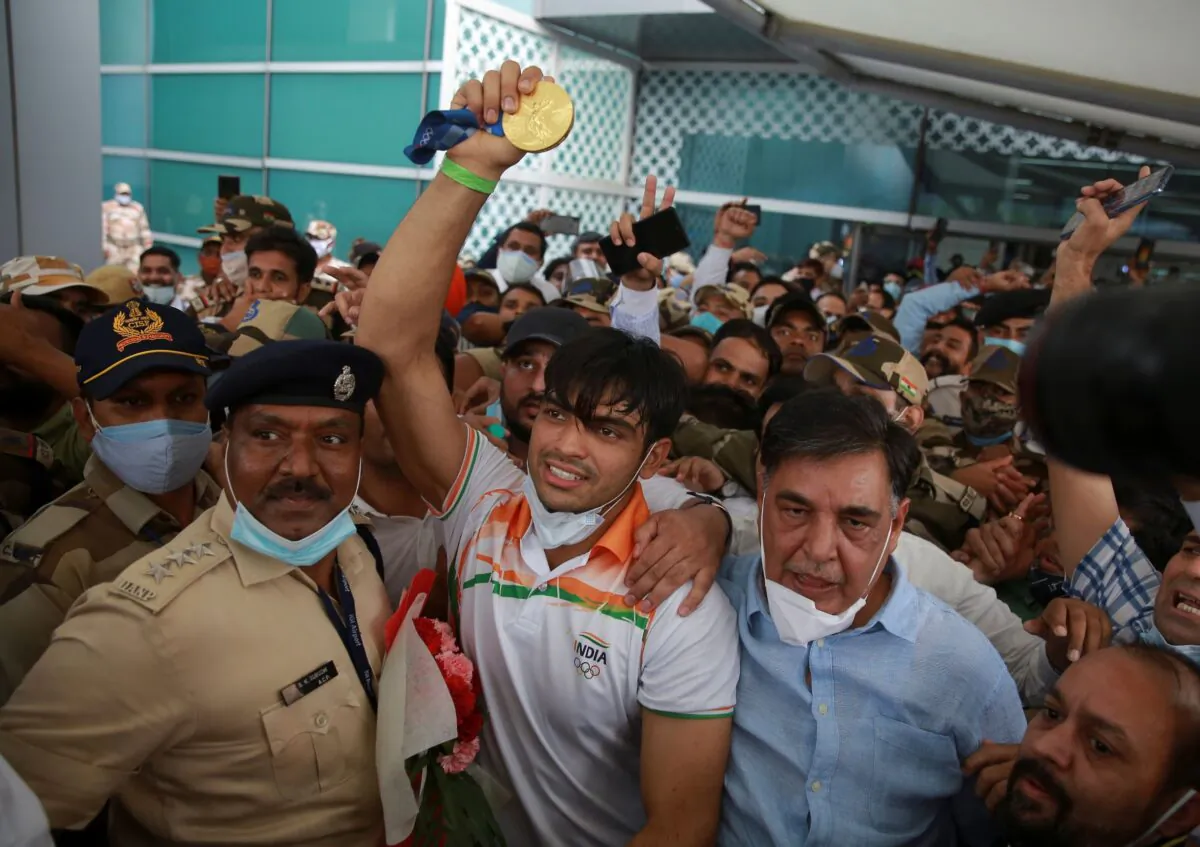 Olympic medalist Neeraj Chopra displays the gold medal he won in the men’s javelin at the Tokyo Games as he arrives for a rousing reception at the Indira Gandhi International Airport in New Delhi, India, on Aug. 9, 2021. (AP Photo)