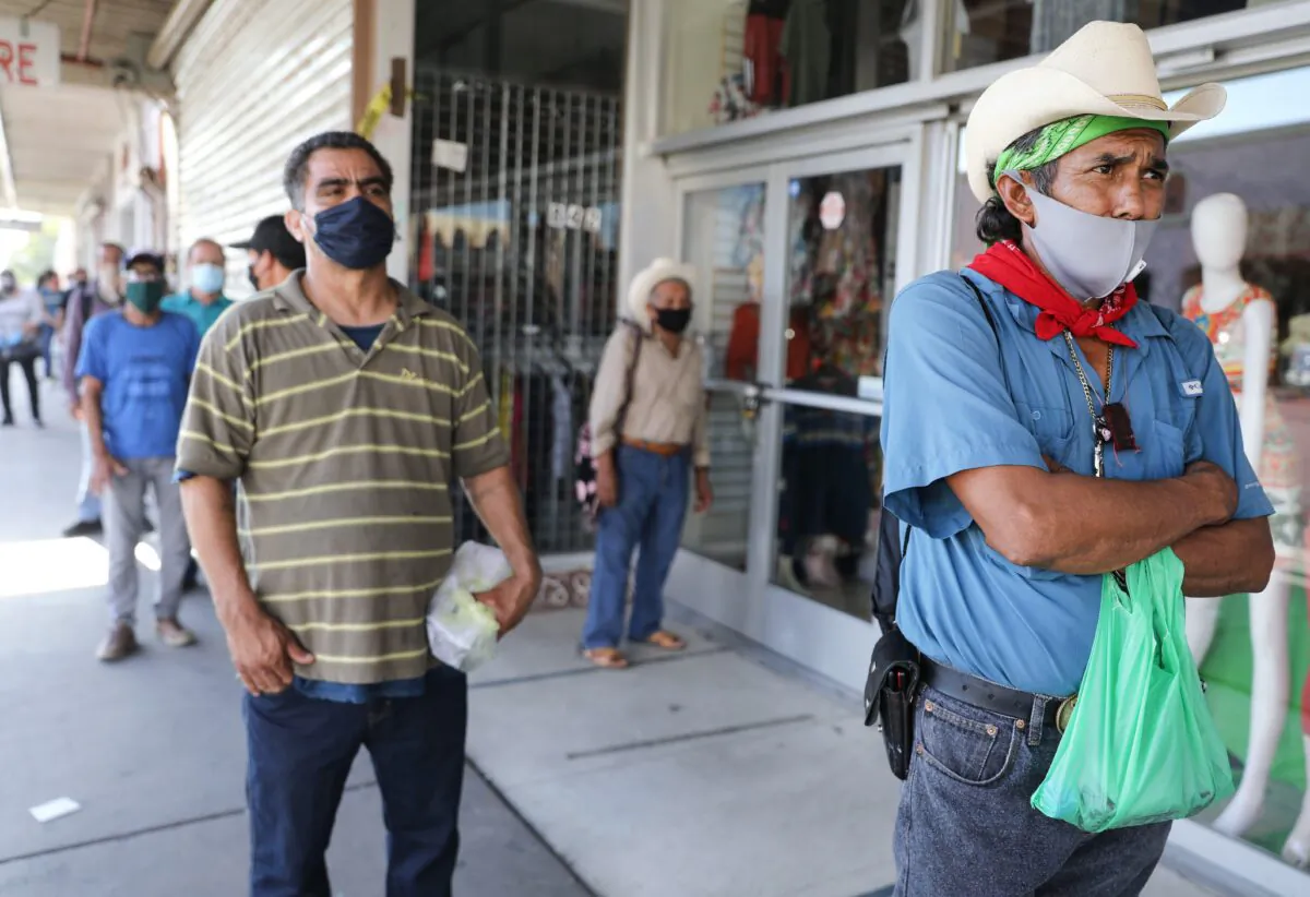 A man who is unemployed waits in line to enter a bookkeeping shop near the U.S.–Mexico border in Calexico, Calif., on July 24, 2020. (Mario Tama/Getty Images)