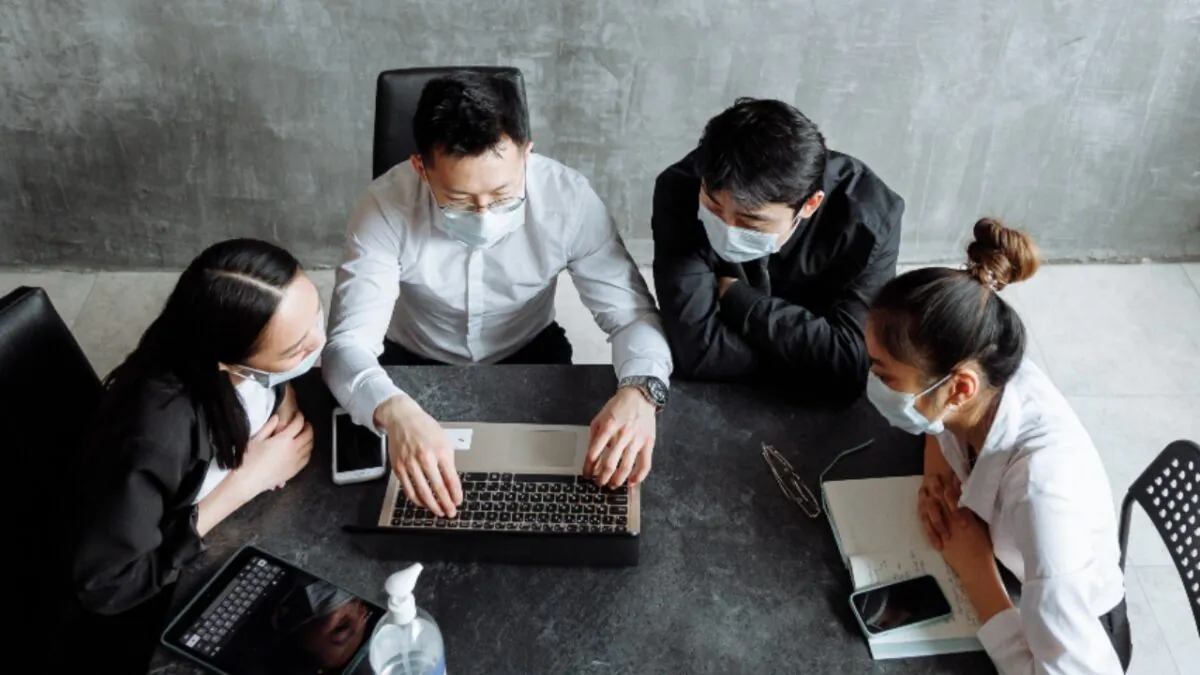 People gather around the table for a meeting. (Pexels)