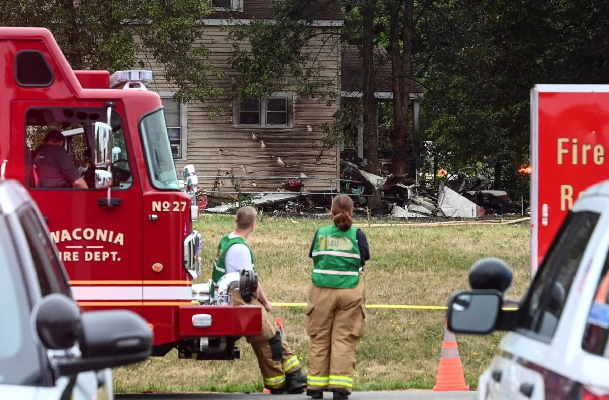 Firefighters look on at the scene of a plane crash, in Victoria, Minn., on Aug. 8, 2021. (Aaron Lavinsky/Star Tribune via AP)