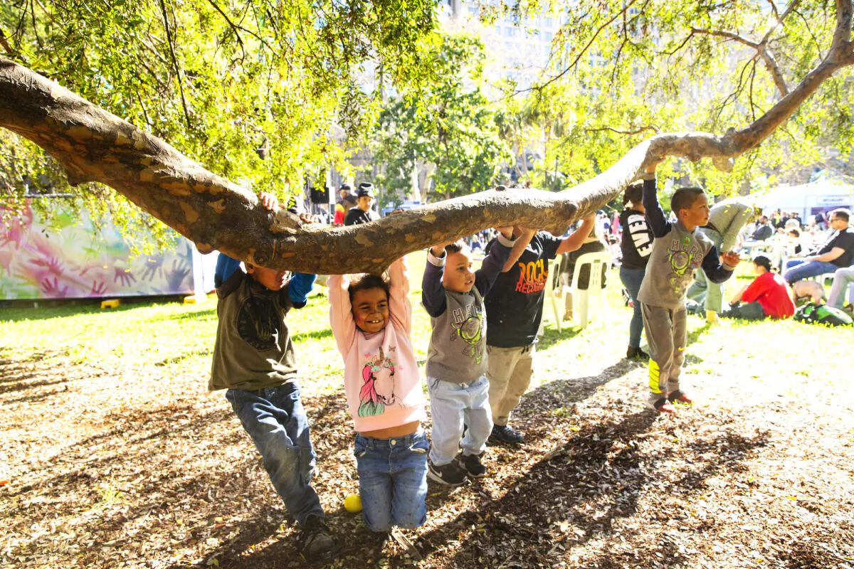 Children play on the branch of a tree at Hyde Park in Sydney, Australia, on July 13, 2019. (Jenny Evans/Getty Images)