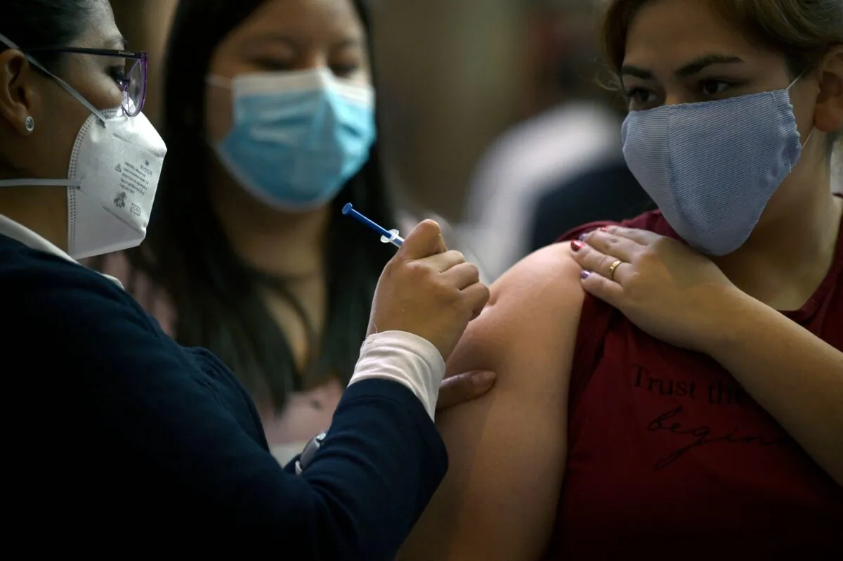 A young woman receives a first dose of the AstraZeneca vaccine against COVID-19 in Mexico City, on Aug. 10, 2021. (Alfredo Estrella/AFP via Getty Images)
