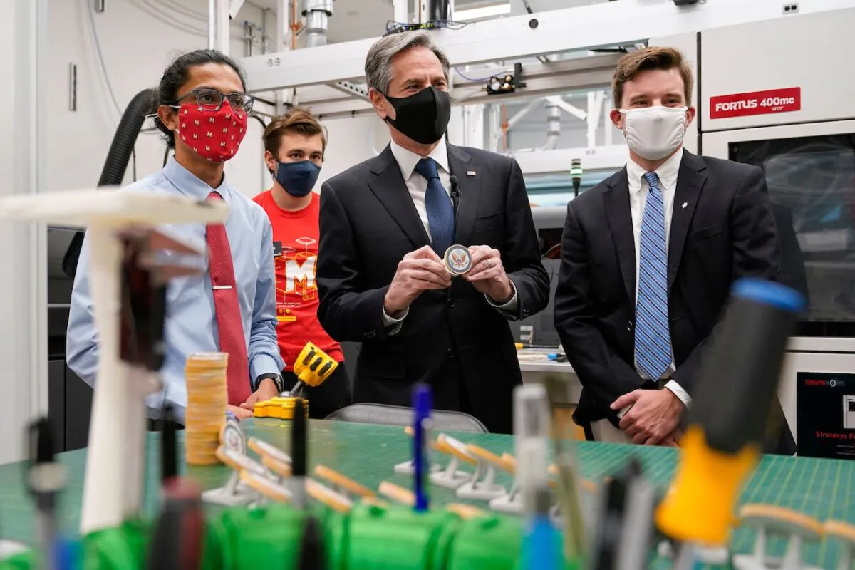 Secretary of State Antony Blinken (C) poses with a 3D-printed Seal of the Department of State as he tours a lab at the University of Maryland's A. James Clark School of Engineering with recent graduate Chinmay Sevak (L) and graduate student Nicholas Bentley (R) before speaking about infrastructure investment, in College Park, Maryland, on Aug. 9, 2021. (Patrick Semansky/POOL/AFP via Getty Images)