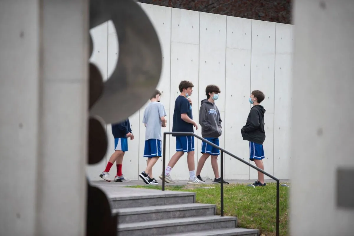 Schoolchildren wear facemasks while talking at a sculpture garden in the Museum District in Houston, Texas, on March 10, 2021. (Mark Felix/AFP via Getty Images)