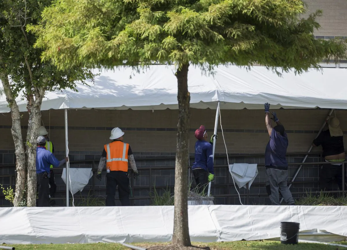 A construction crew works to set up tents that hospital officials plan to use with an overflow of COVID-19 patients outside of Lyndon B. Johnson Hospital in Houston, Texas, on Aug. 9, 2021, in Houston. (Godofredo A. Vásquez/Houston Chronicle via AP)