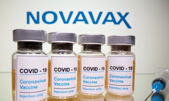 Vial with sticker reading, "COVID-19 / coronavirus vaccine / injection only" A medical syringe can be seen in front of the displayed Novavax logo in this figure, taken on October 31, 2020.  (DadoRuvic / Illustration / Reuters)