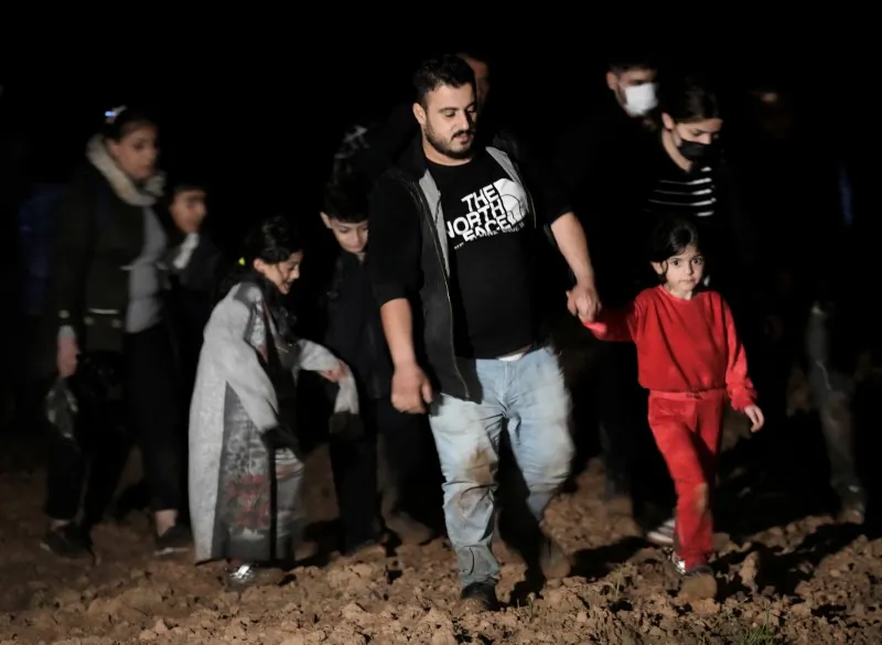 Detained migrants, who have crossed the Belarus-Latvia border, walk next to the border area near Vorzova, Latvia, Aug. 11, 2021. (Ints Kalnins/Reuters)