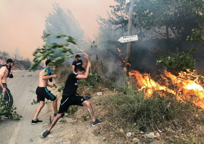 People attempt to put out a fire in the mountainous Tizi Ouzou province, east of Algiers, Algeria, on Aug. 10, 2021. (Abdelaziz Boumzar/Reuters)
